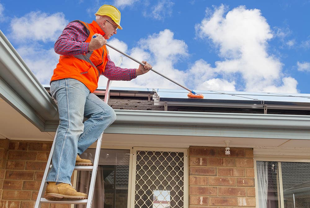 man wiping off the solar panels