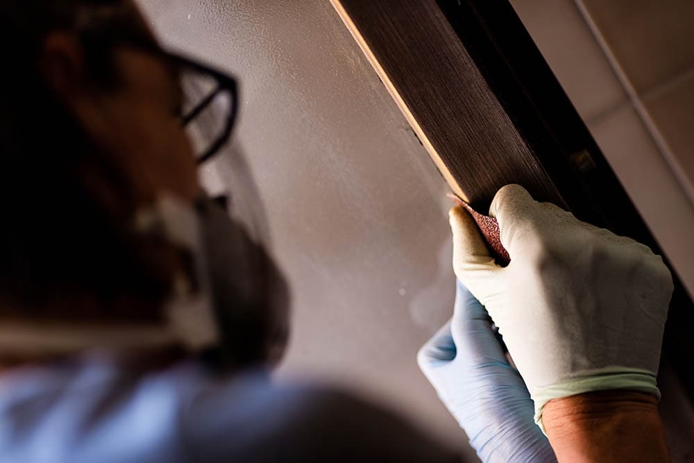 person sanding a door