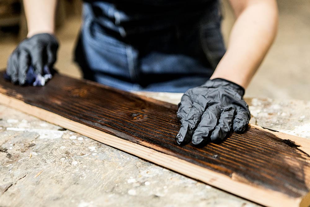 person varnishing lumber