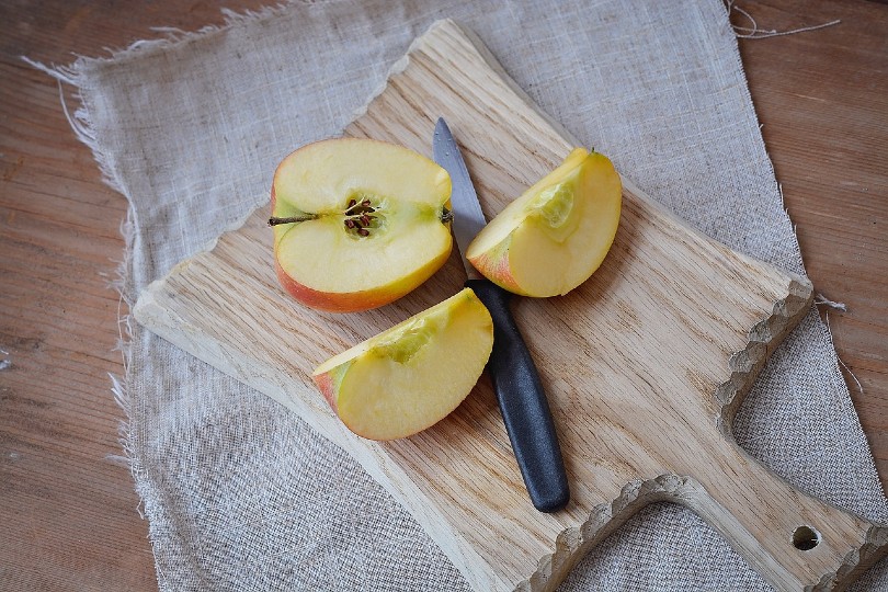 sliced apple on wooden cutting board