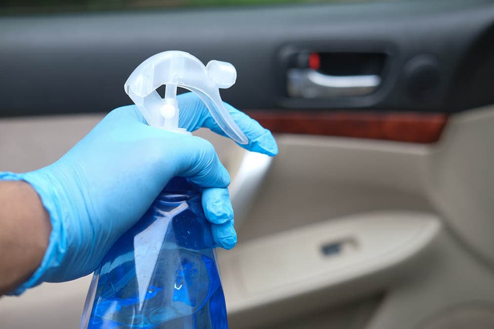 spraying homemade cleaner in the car