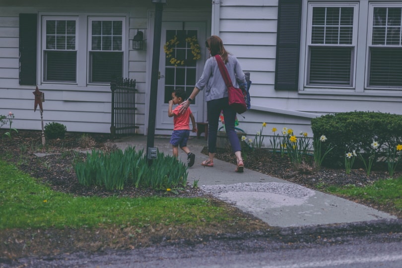 woman and her child walking toward house