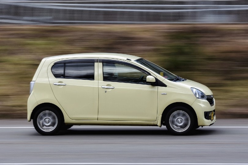 yellow compact car on the road