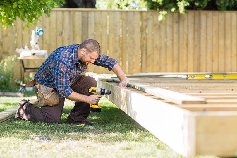 carpenter drilling wood at construction site