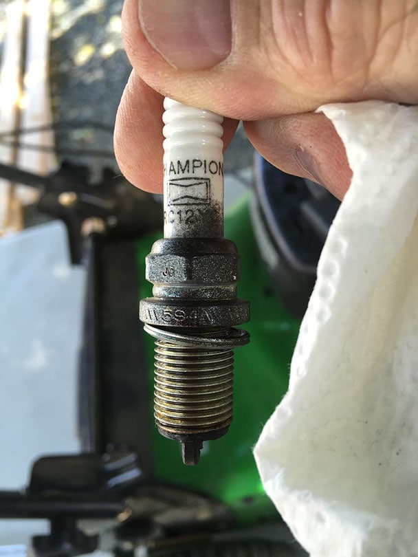 close up hand holding a spark plug
