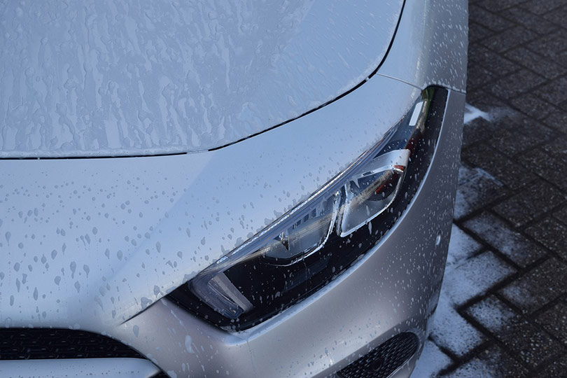 grey car exterior sprayed with soap