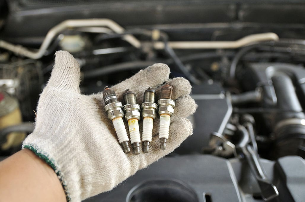 hand showing four spark plugs
