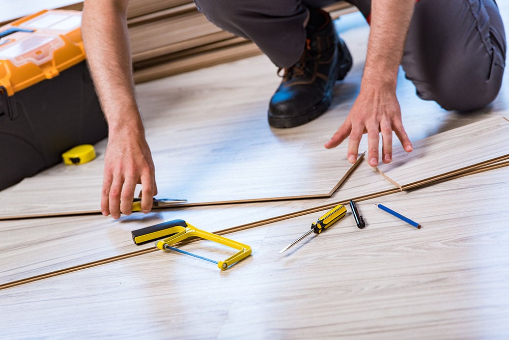 man installing laminated flooring
