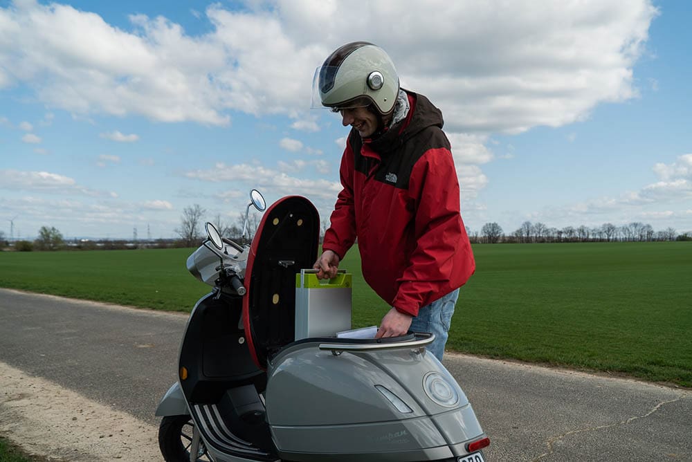 man installing motorycle battery of electric motorcyle