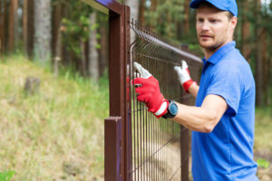 man installing steel fence