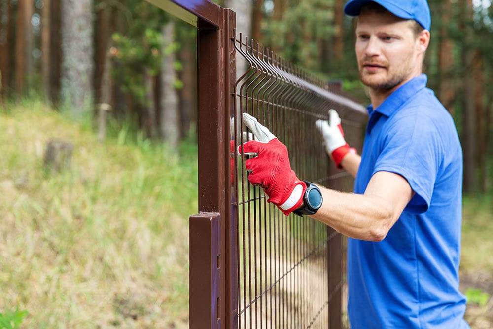 man installing steel fence