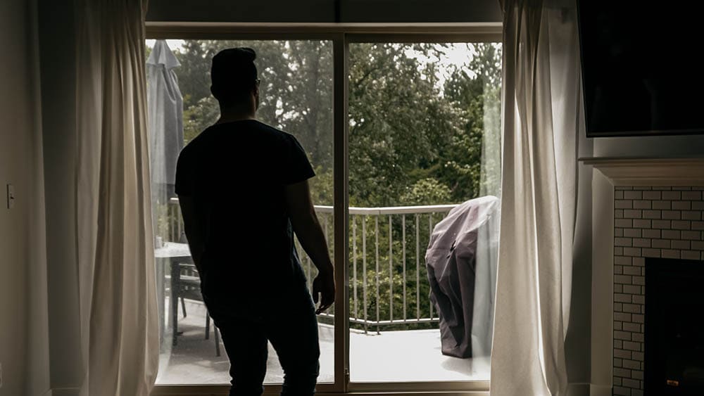 man walking towards the sliding glass door