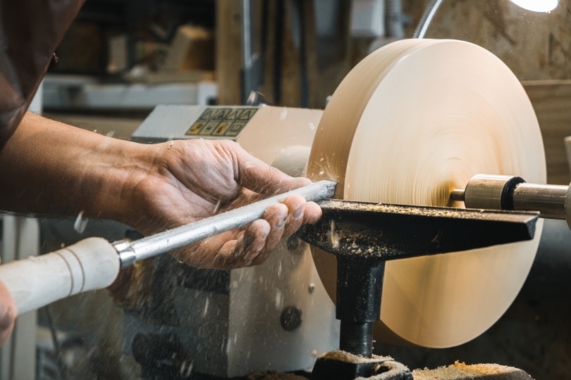 man works on wood turning