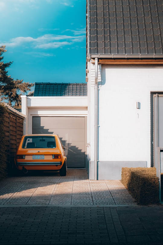 orange car parked on a permeable driveway