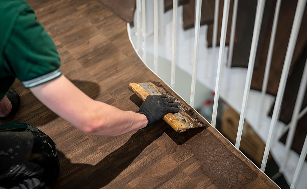 person applying wood putty on the floor
