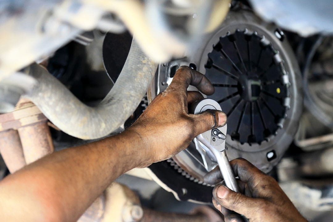 person fixing car clutch