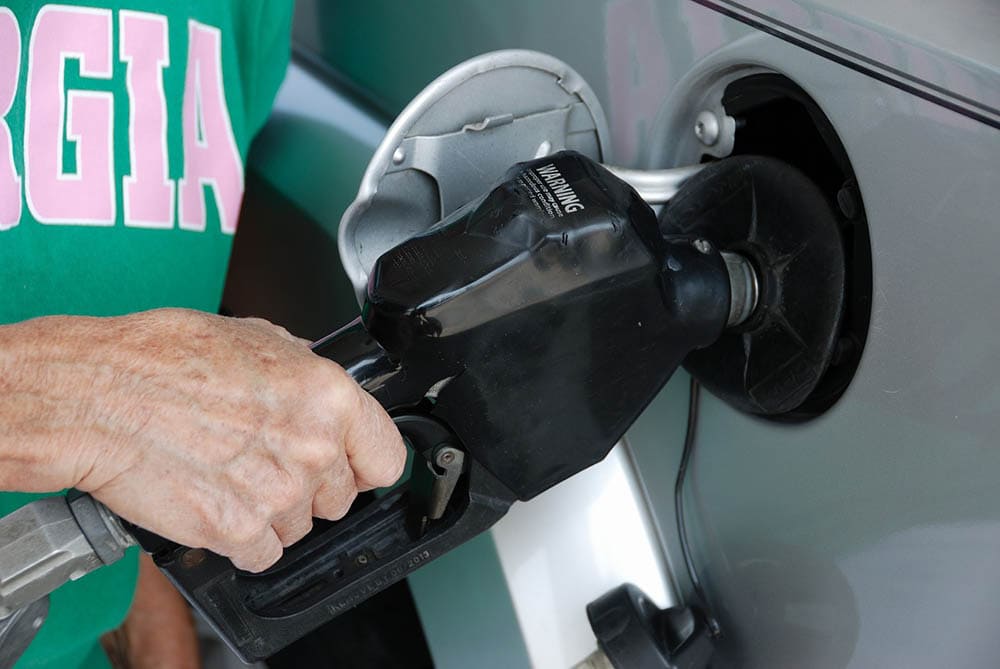 person pumping gas on the car