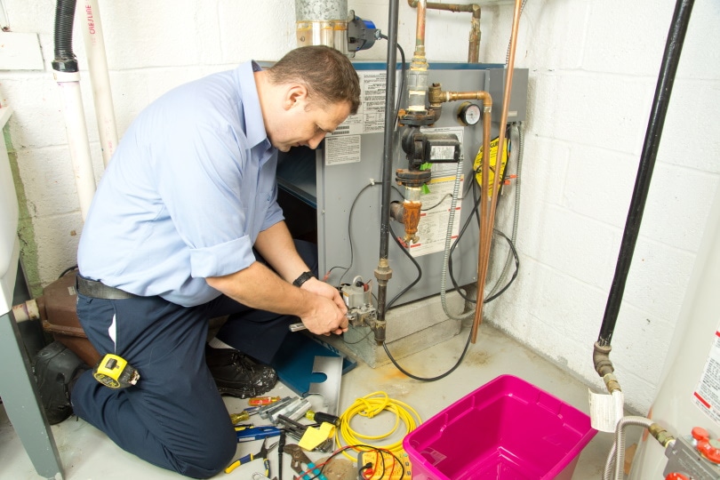 plumber fixing gas furnace