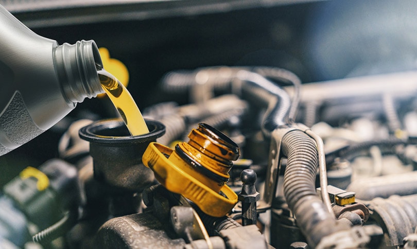 pouring oil to car engine during oil change