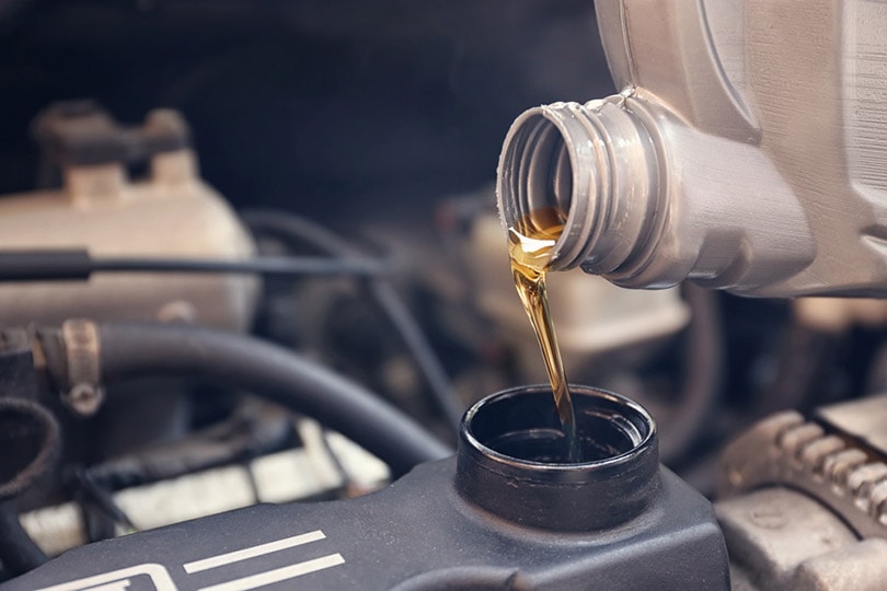 pouring oil to car engine