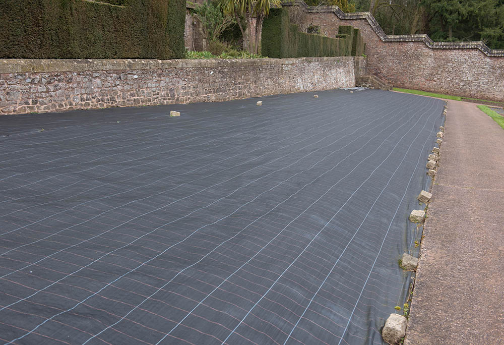 securing landscape fabric with brick stones