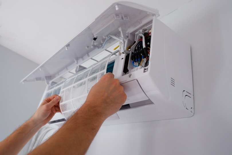 technician is cleaning the filter of AC