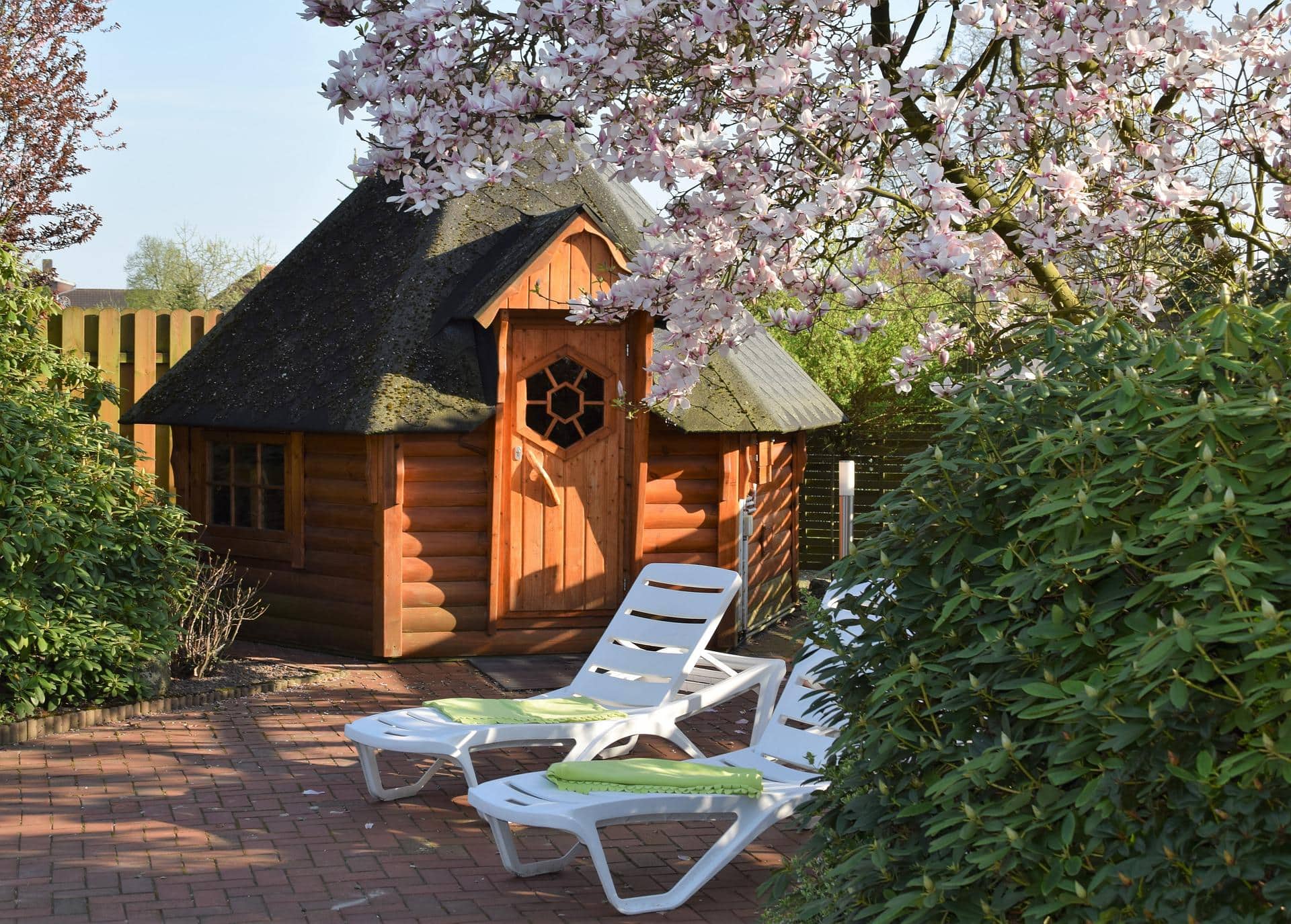 Outdoor sauna in the garden with deck chairs