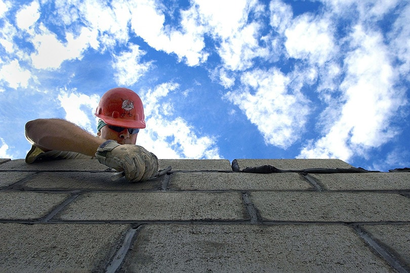 bricklayer laying concrete bricks