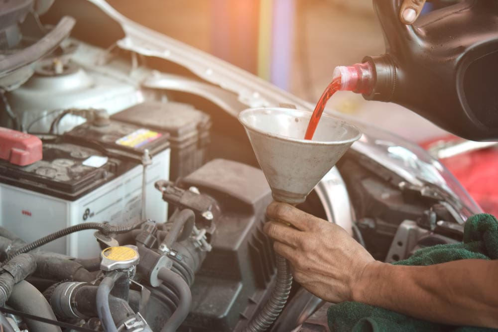 filling up car engine with new transmission fluid