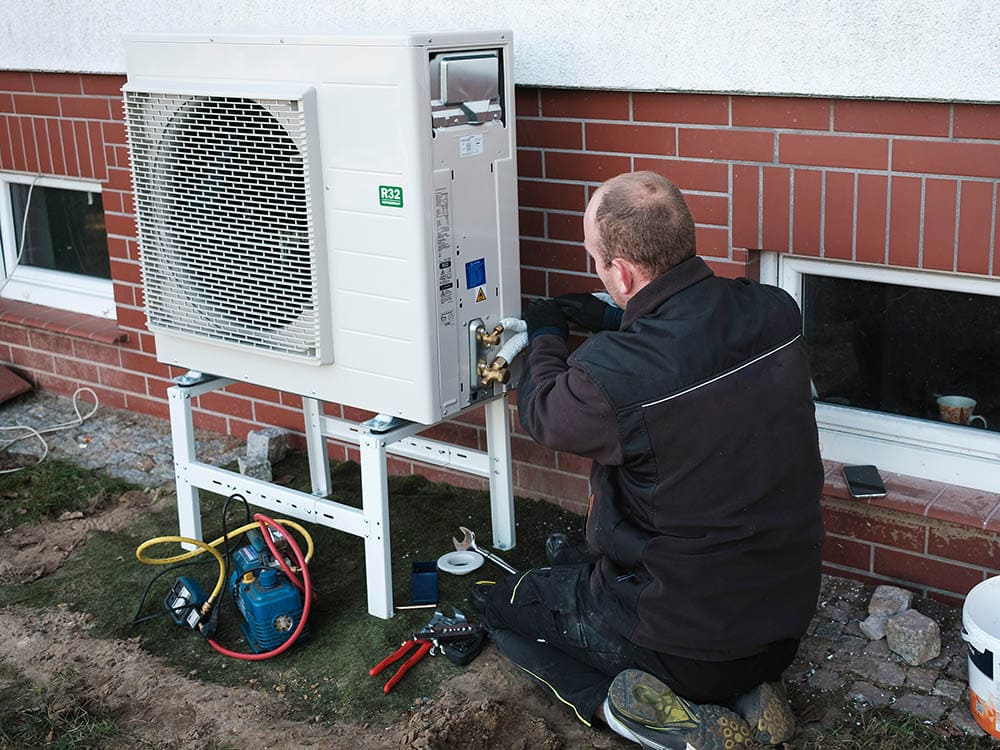 man fixing the heat pump