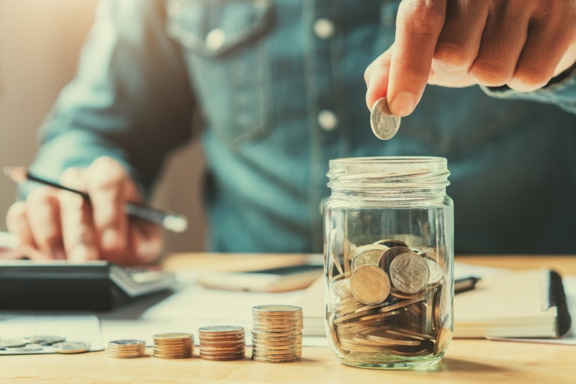 man holding coin putting in glass