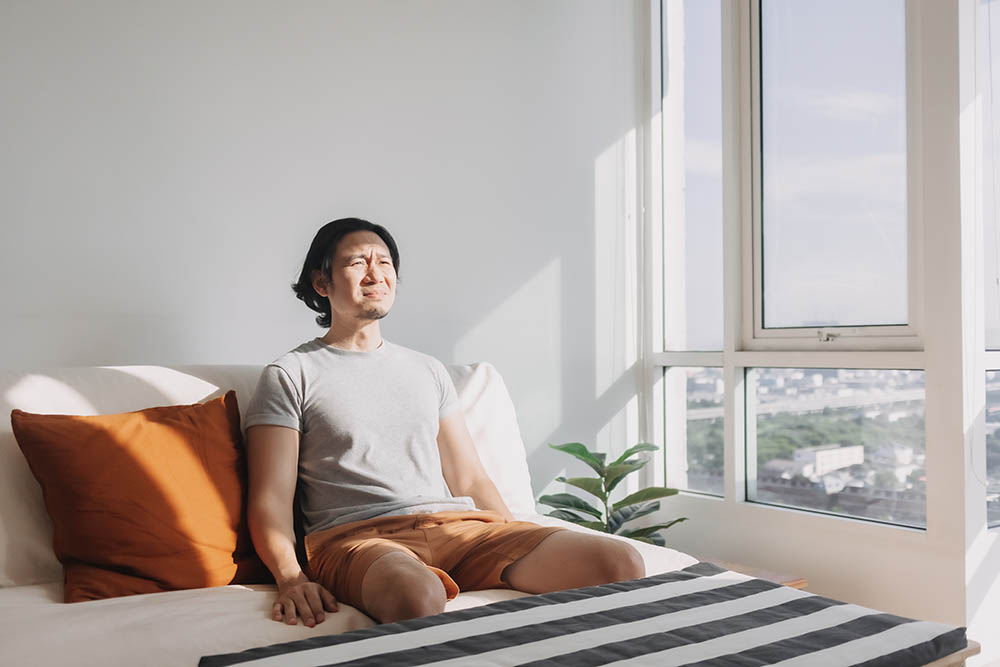 man in his bed near the window