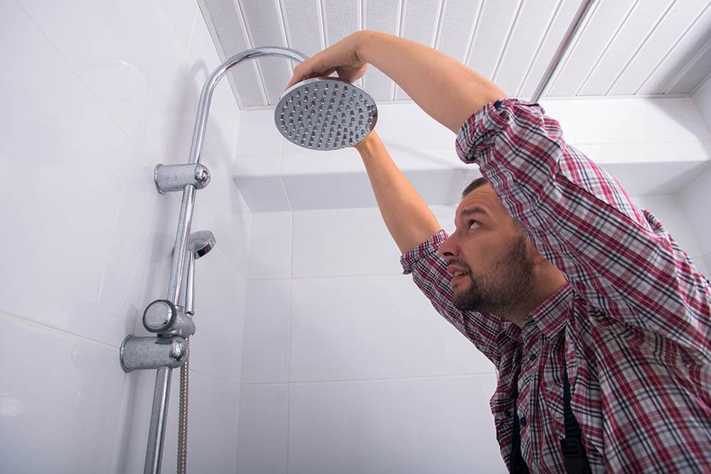 man replacing shower head