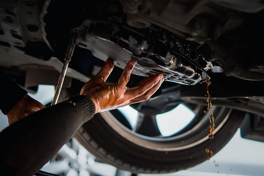 mechanic draining the old automatic transmission fluid
