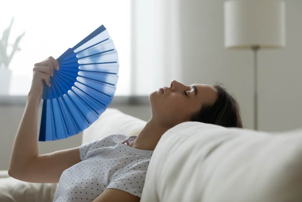 woman exhausted from heat fanning herself