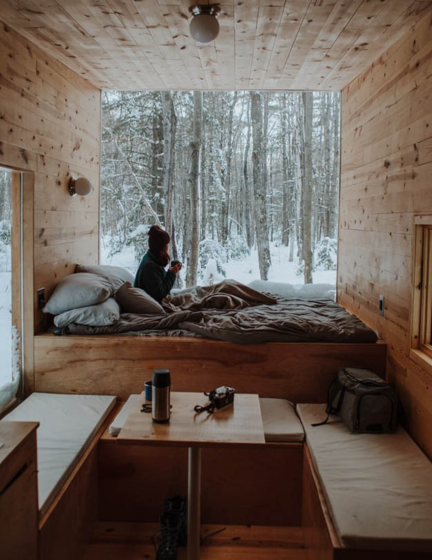 woman getting cozy near the window during winter