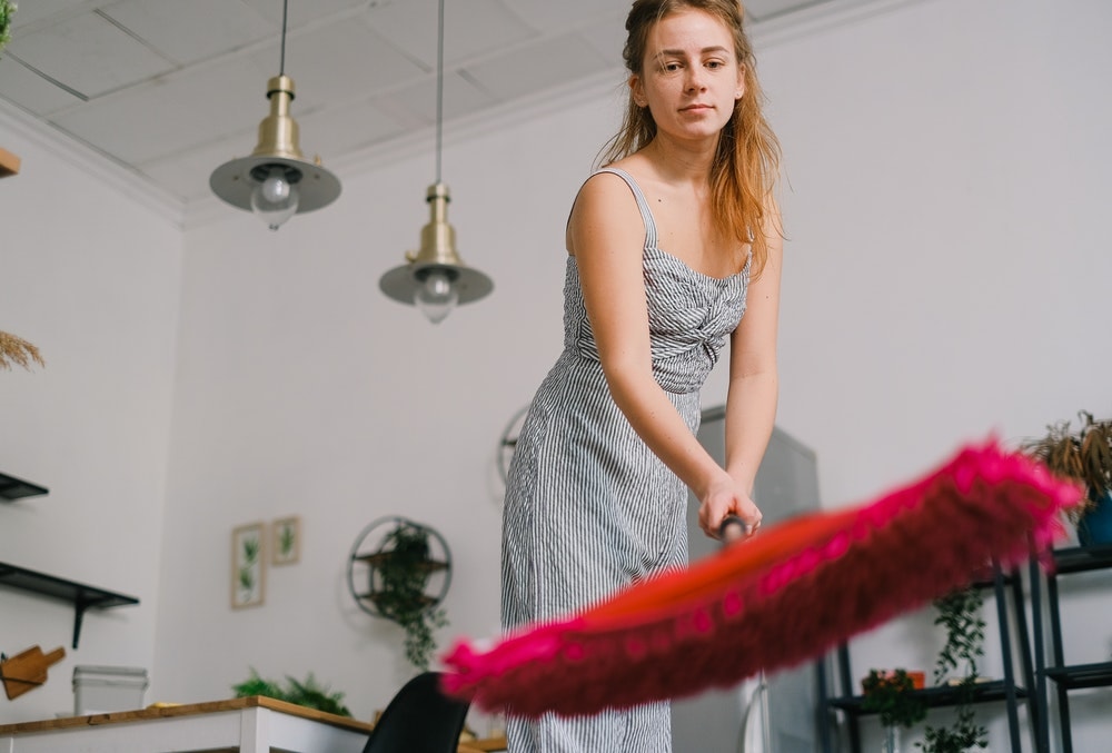 Woman holding a pink floor mop