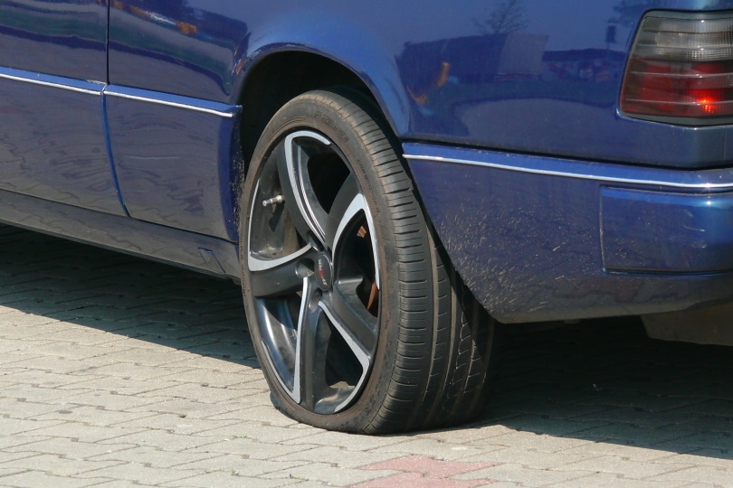 blue car with flat tire