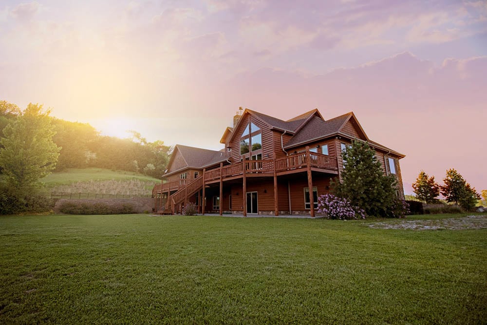 brown log house in the middle of fields