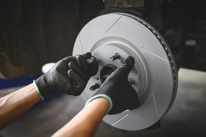 car mechanic installing brake rotor