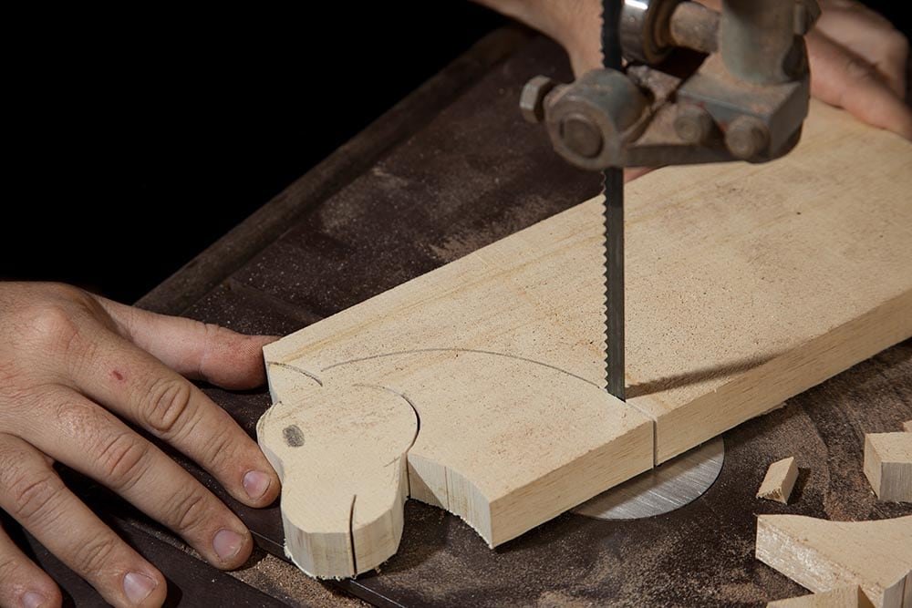 close up craftsman cutting wood using bandsaw