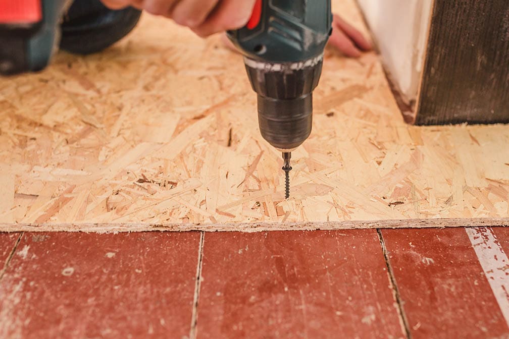 close up person installing subfloor