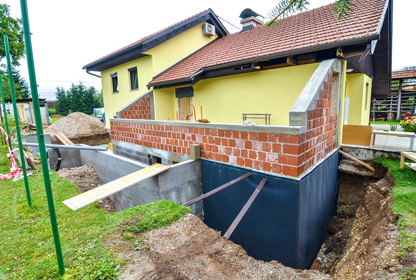 digging the brick foundation of a house for hydro isolation of basement