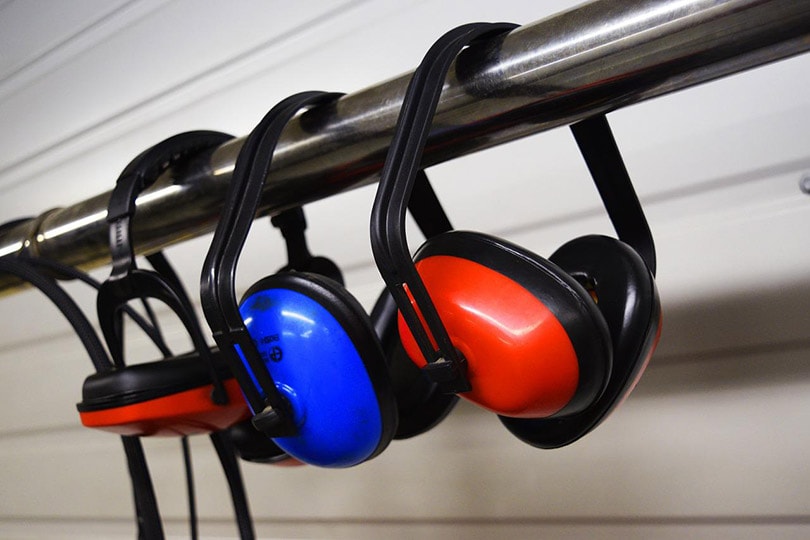 earmuffs hanging on aluminum bar