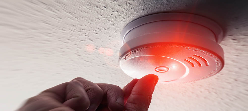 finger pressed the smoke detector test button