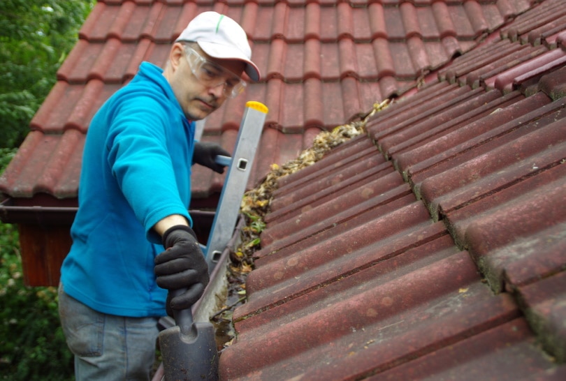 man cleaning gutter
