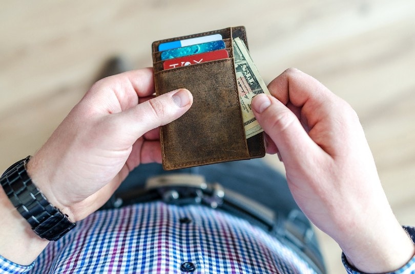 man getting cash out from his wallet