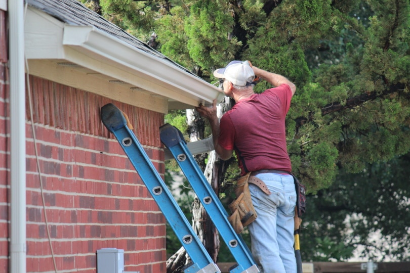 man installing roof gutter