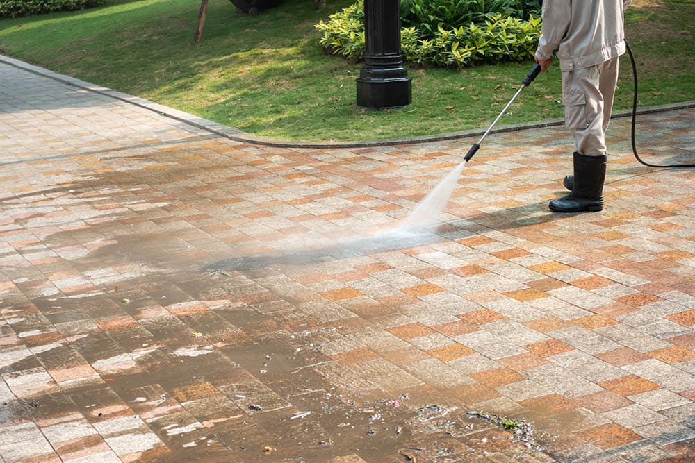 man pressure washing the driveway