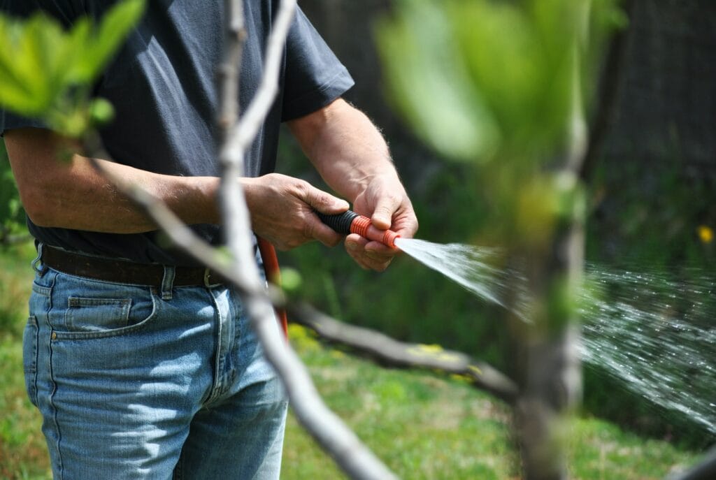 man spraying hose
